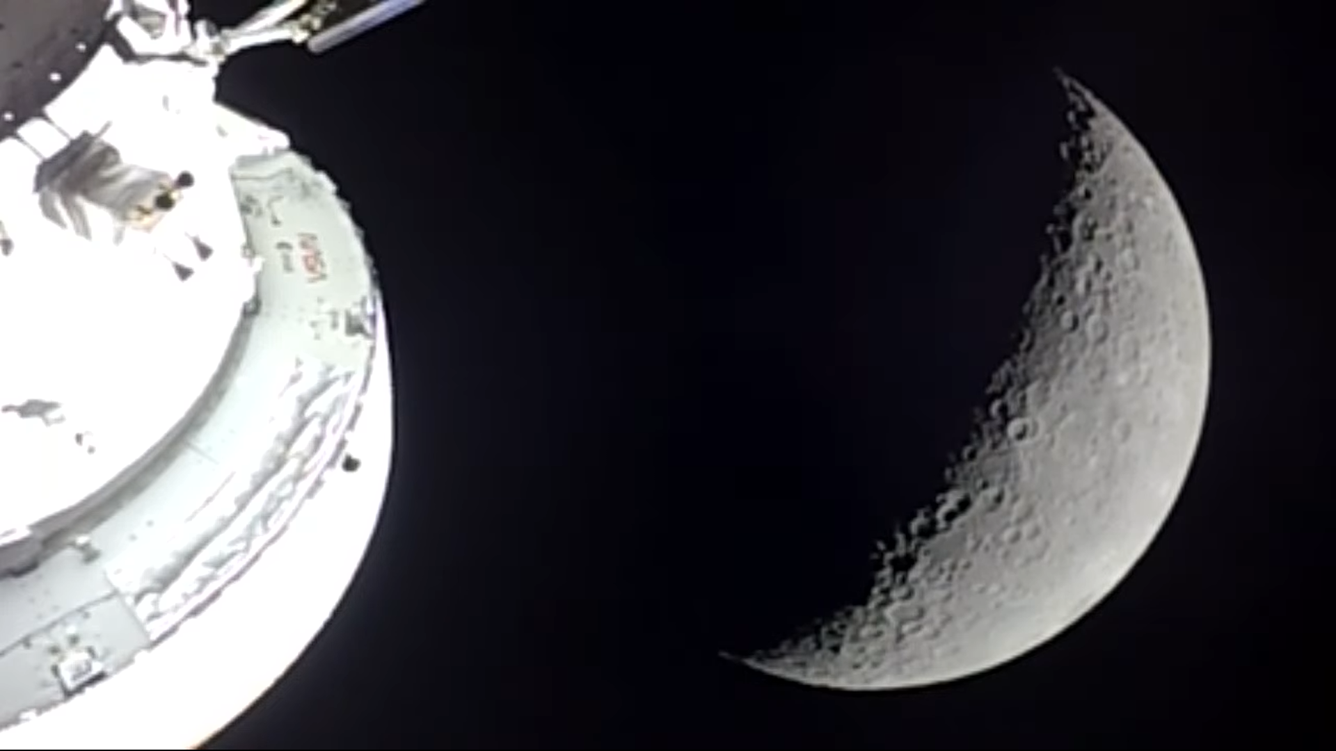A view from the livestream showing the moon with the Orion spacecraft in front of it.
