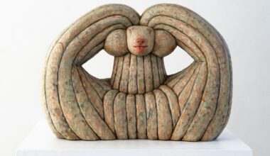 a wood-carved sculpture of a dog by Misato Sano