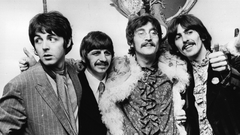 The Beatles smiling and standing together late '60s