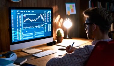 An investor sitting in a dark room looking at their computer screen, which is displaying a stock or cryptocurrency chart.