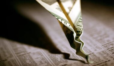 A twenty dollar bill paper airplane that's crashed and crumpled into a financial newspaper.