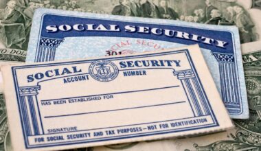 Two Social Security cards (one older) atop a stack of U.S. paper currency.