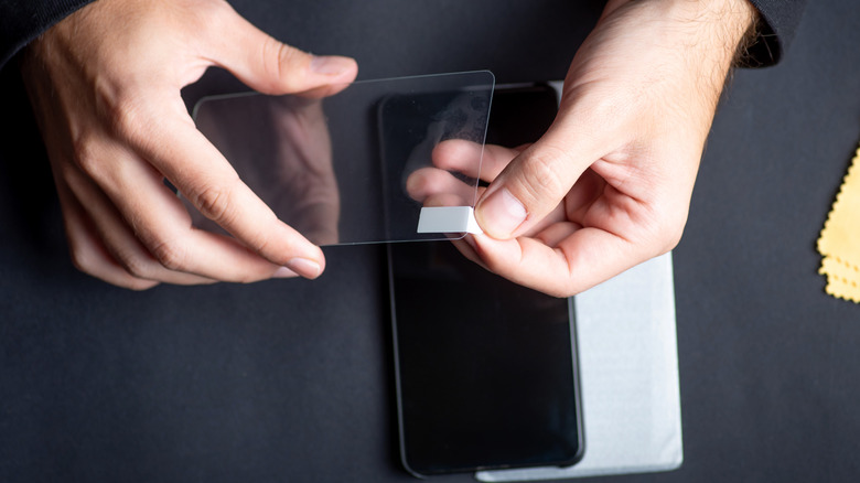 Man holding a protective glass that he wants to put on device