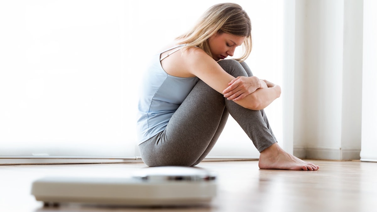 Woman sitting on the floor upset