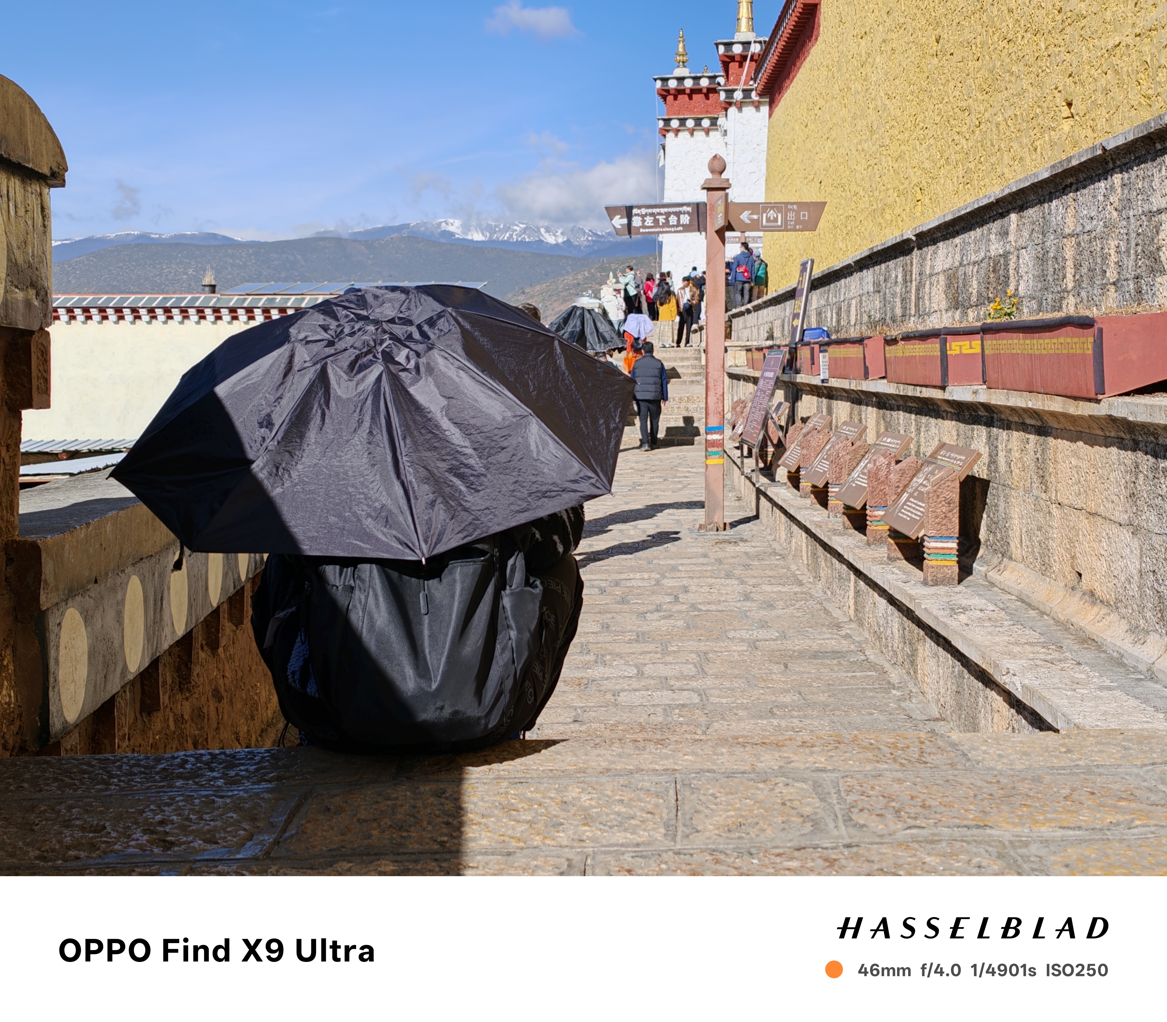 Person sat on a step in the sun, holding an umbrella