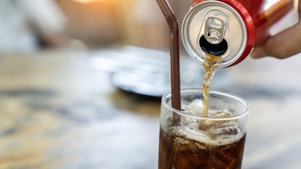 A soft drink being poured into a glass