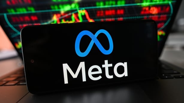 In this photo illustration, the Meta logo is displayed on a smartphone with stock market percentages in the background 