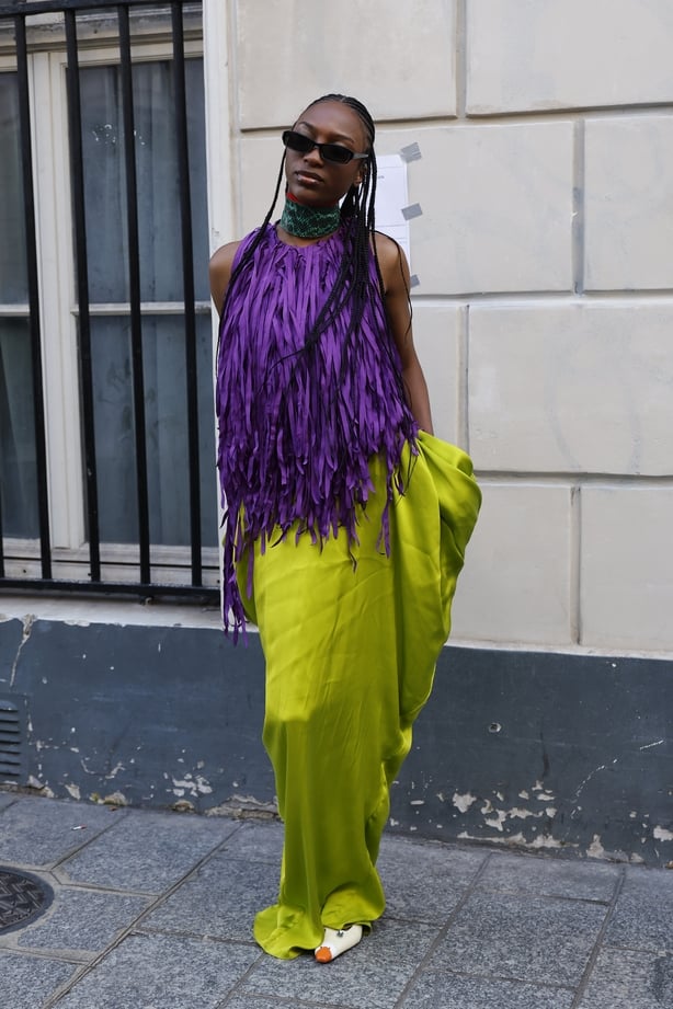 Cindy Miranda wears purple fringed sleeveless top, green snake skin print collar, neon green satin maxi skirt