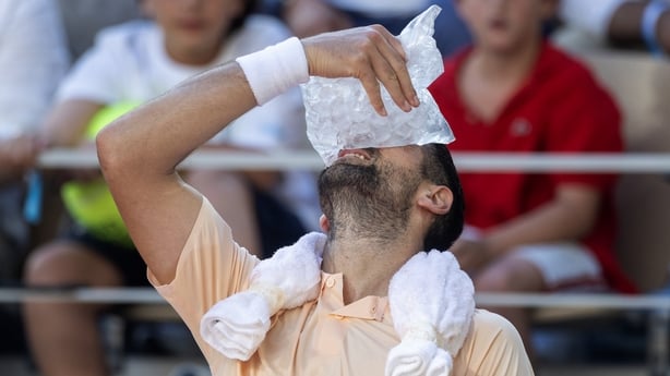 Tennis player Novak Djokovic cools off during a match at the French Open