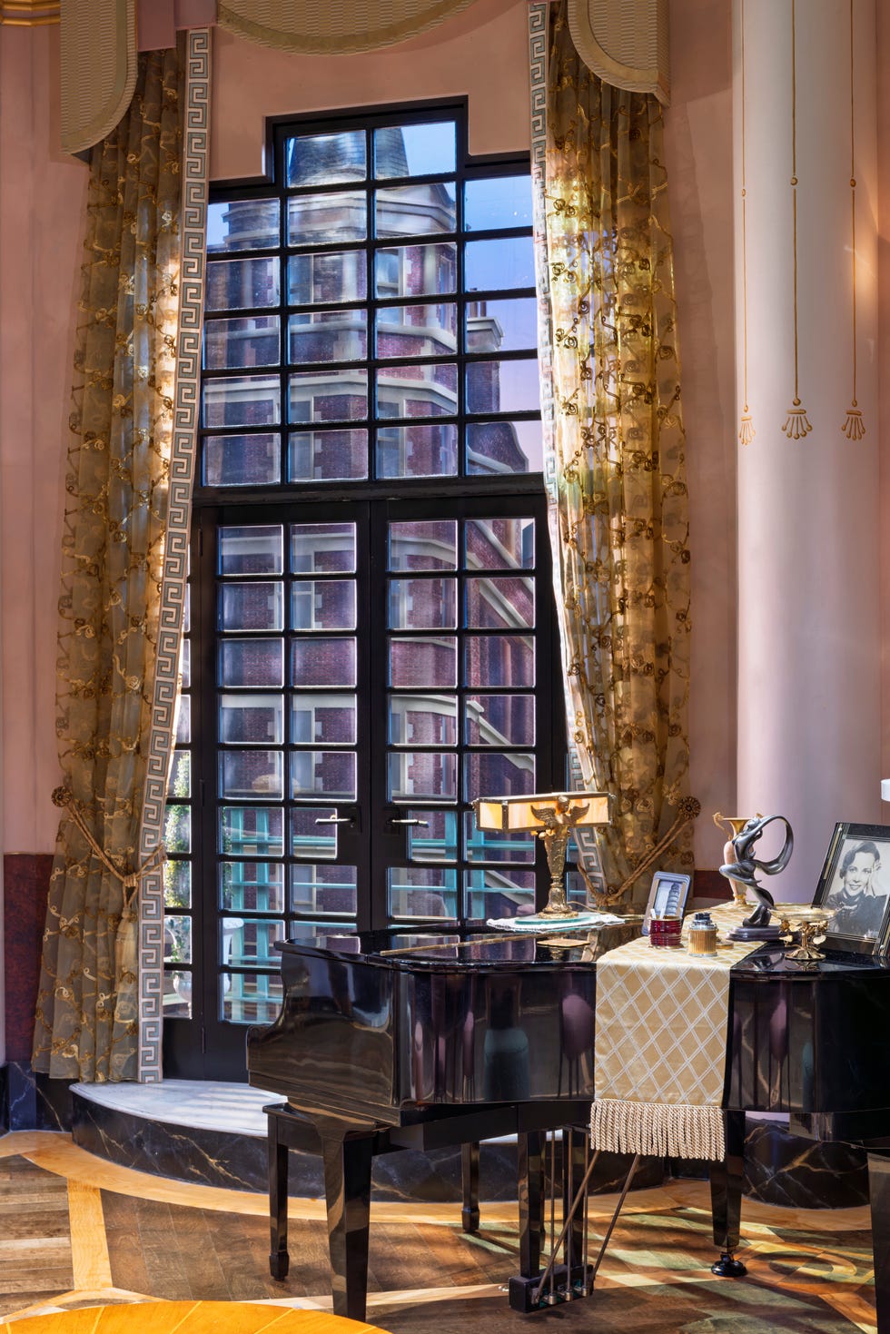 Theater set featuring a grand piano and a large window.
