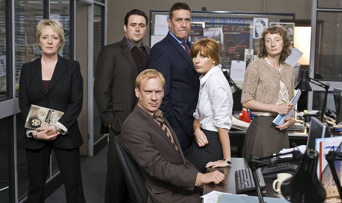 A group of people stand in an office setting