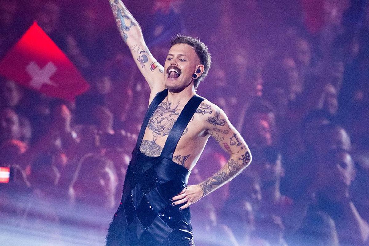 A man raises his arm as he performs on stage