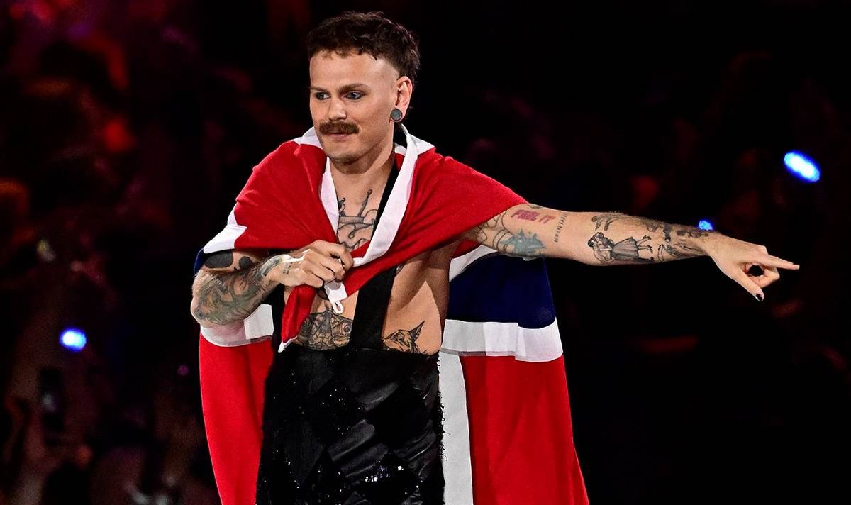 A man wears a Norwegian flag around his shoulders