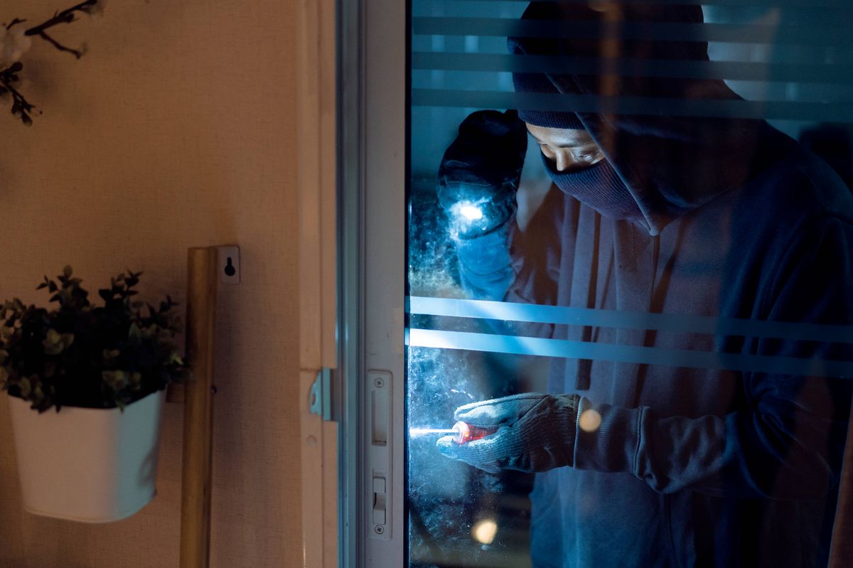 A burglar breaking into a house (stock)