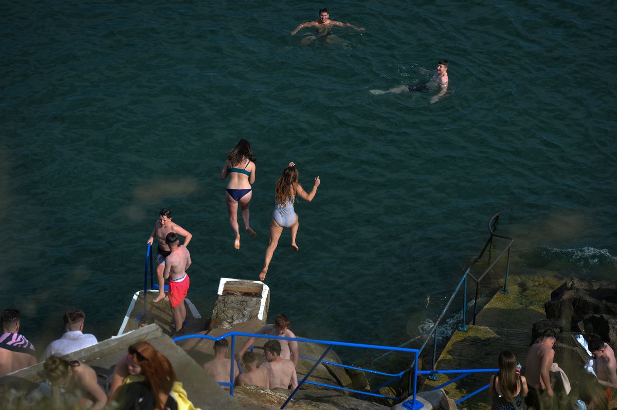 Swimmers jump into the sea at the Vico bathing place, Hawk Cliff, in Dalkey