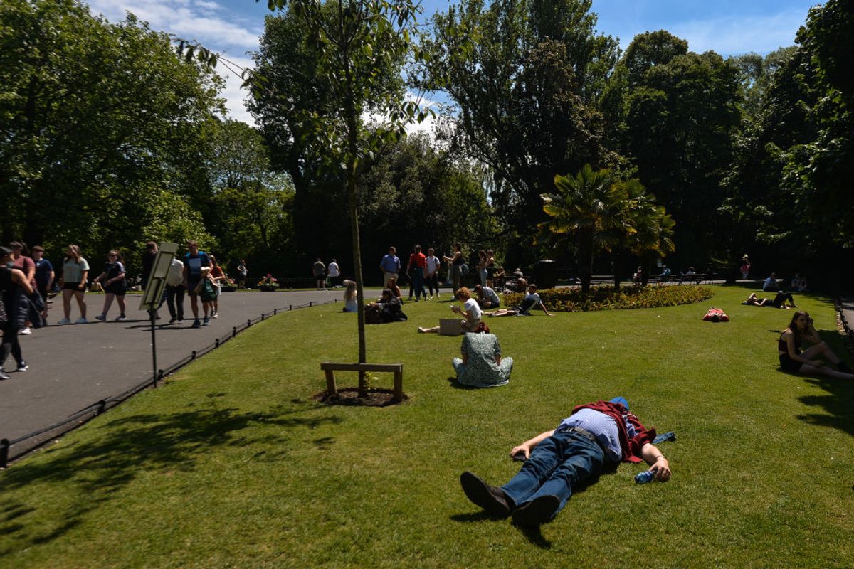 People enjoy the nice weather in St. Stephens Green in Dublin.
