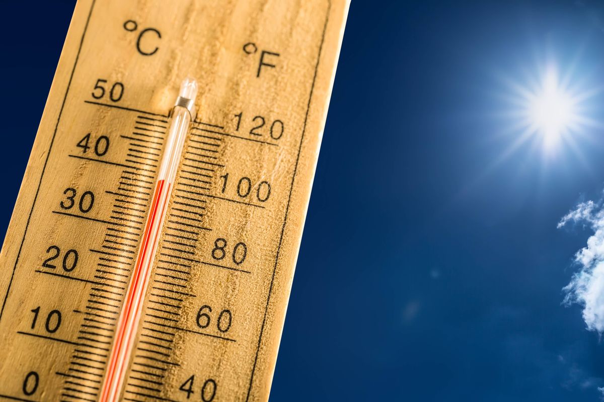 Hot summer day and forty degrees Celsius on a thermometer. Thermometer in summer day shows high temperature degree with sun in background.