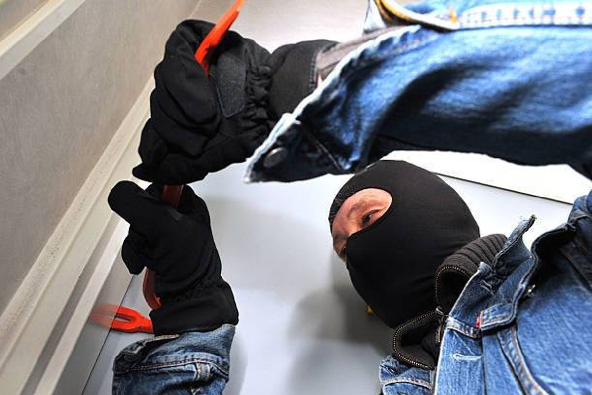 Man wearing a balaclava, holding a wrecking bar