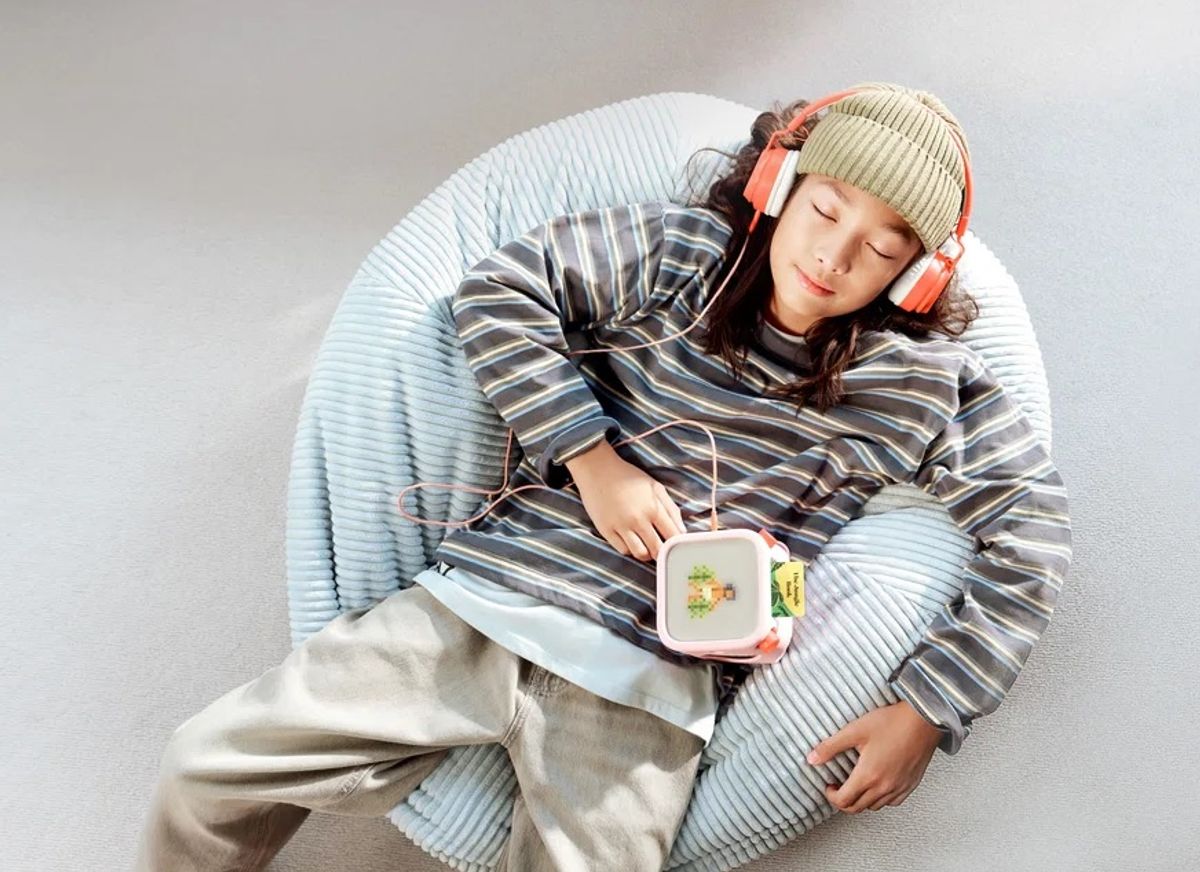 Child relaxing on a beanbag while listening to a Yoto Player