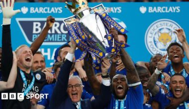 Leicester City manager Claudio Ranieri and captain Wes Morgan lift the Premier League trophy while surrounded by euphoric Foxes players