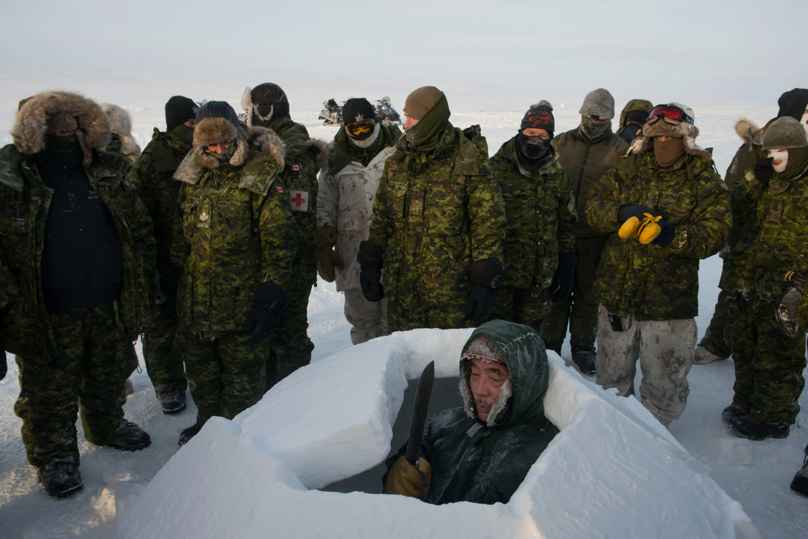 An Inuit Canadian Ranger teaches igloo-building to soldiers.