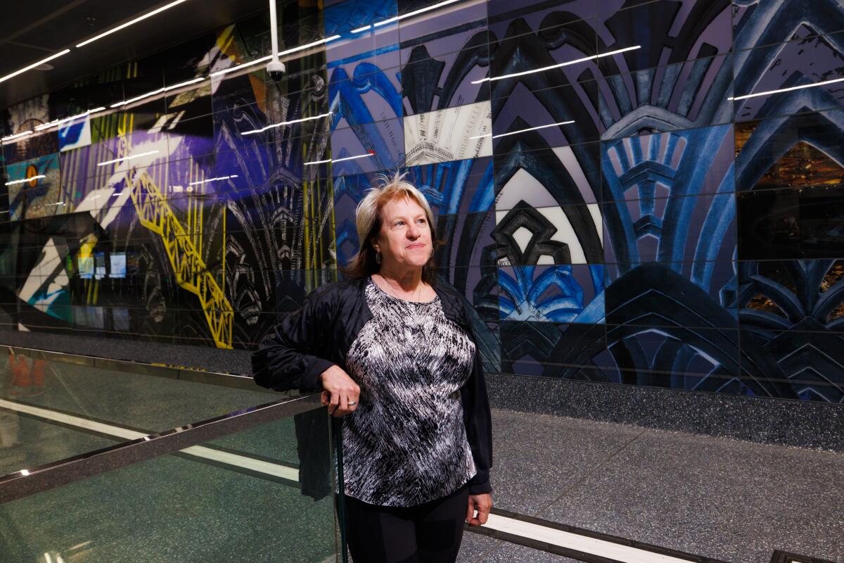 Artist Fran Siegel stands in front of her artwork at the Wilshire/La Brea Metro Station 