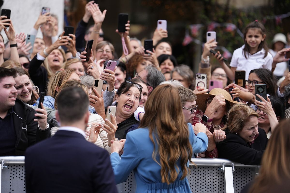 Wellwishers try to shake hands and take pictures of the princess 