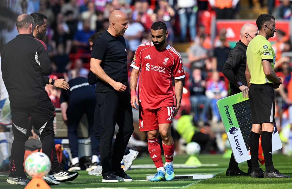 Mohamed Salah of Liverpool talks with Arne Slot, Manager of Liverpool, as he is substituted off after picking up an injury during the Premier League match between Liverpool and Crystal Palace at Anfield on April 25, 2026 in Liverpool, England