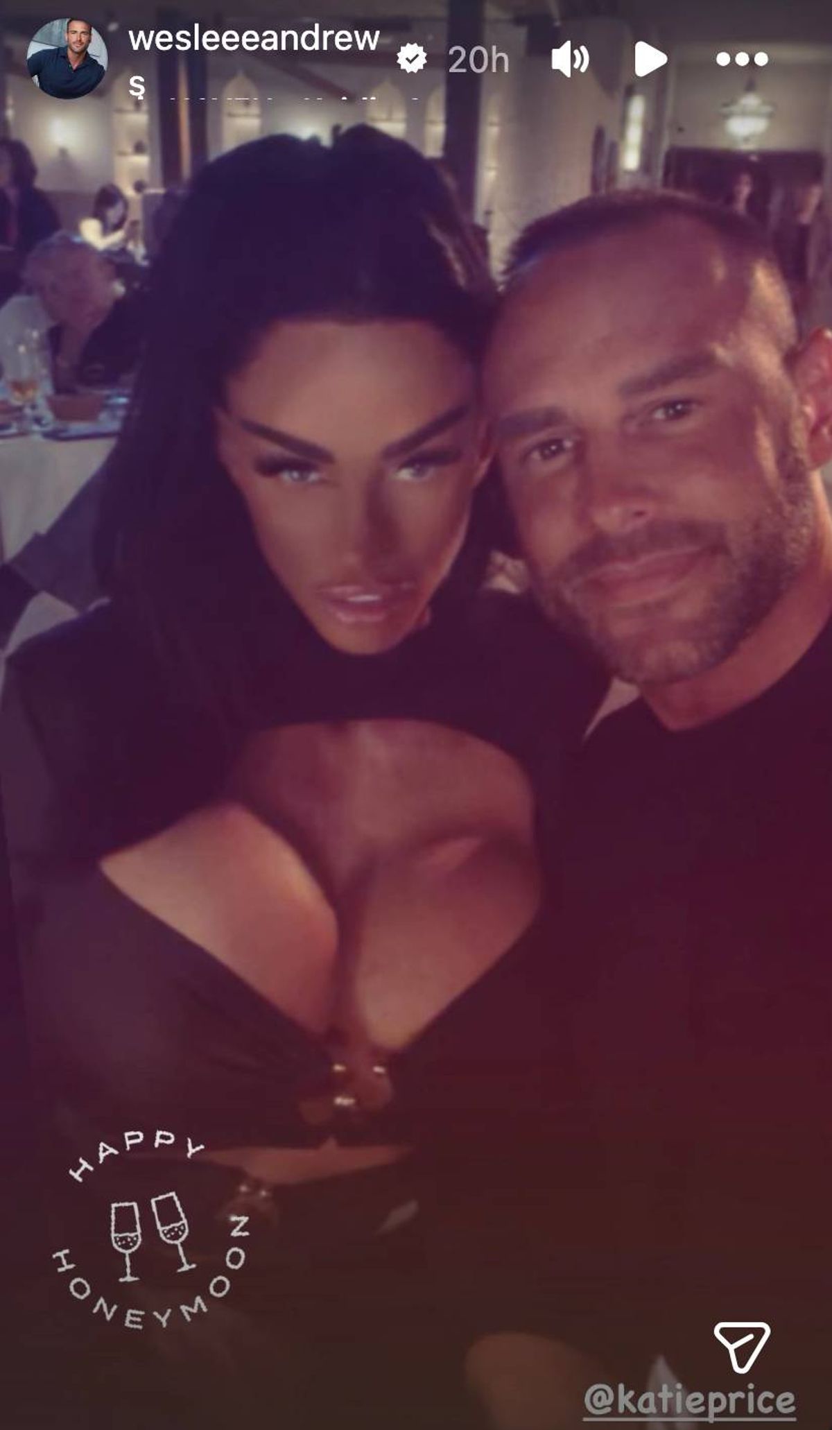 An image depicting an individual with dark hair standing closely alongside another individual sporting facial hair. Both individuals are engaged in a friendly pose for a photograph, likely taken during a social event.