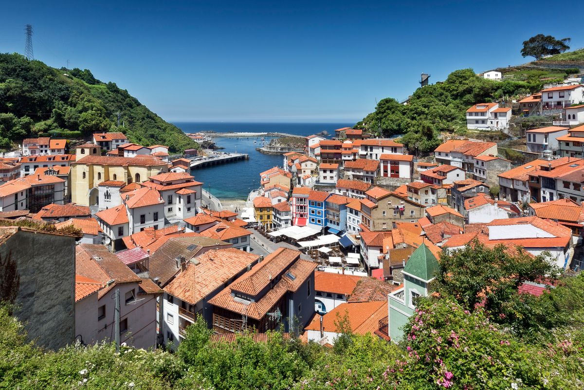 Aerial view of the coloured rooftops of Cudillero, a touristic village and fishing port in Asturias, Spain, on a sunny day.
