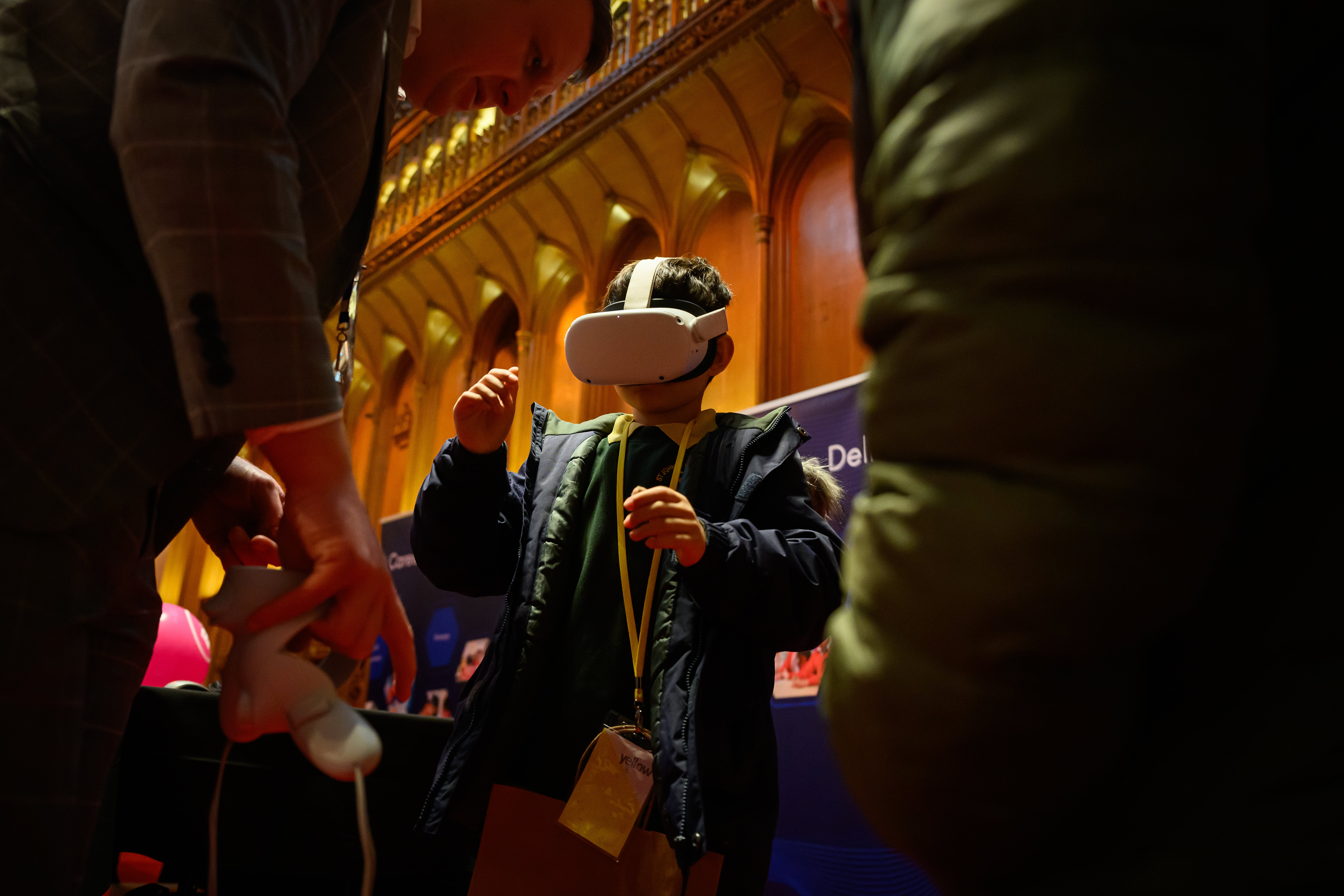 Primary school children try on VR headsets as they speak with a representative of Metaverse Learning