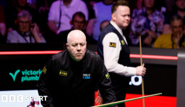 John Higgins eyes a shot
