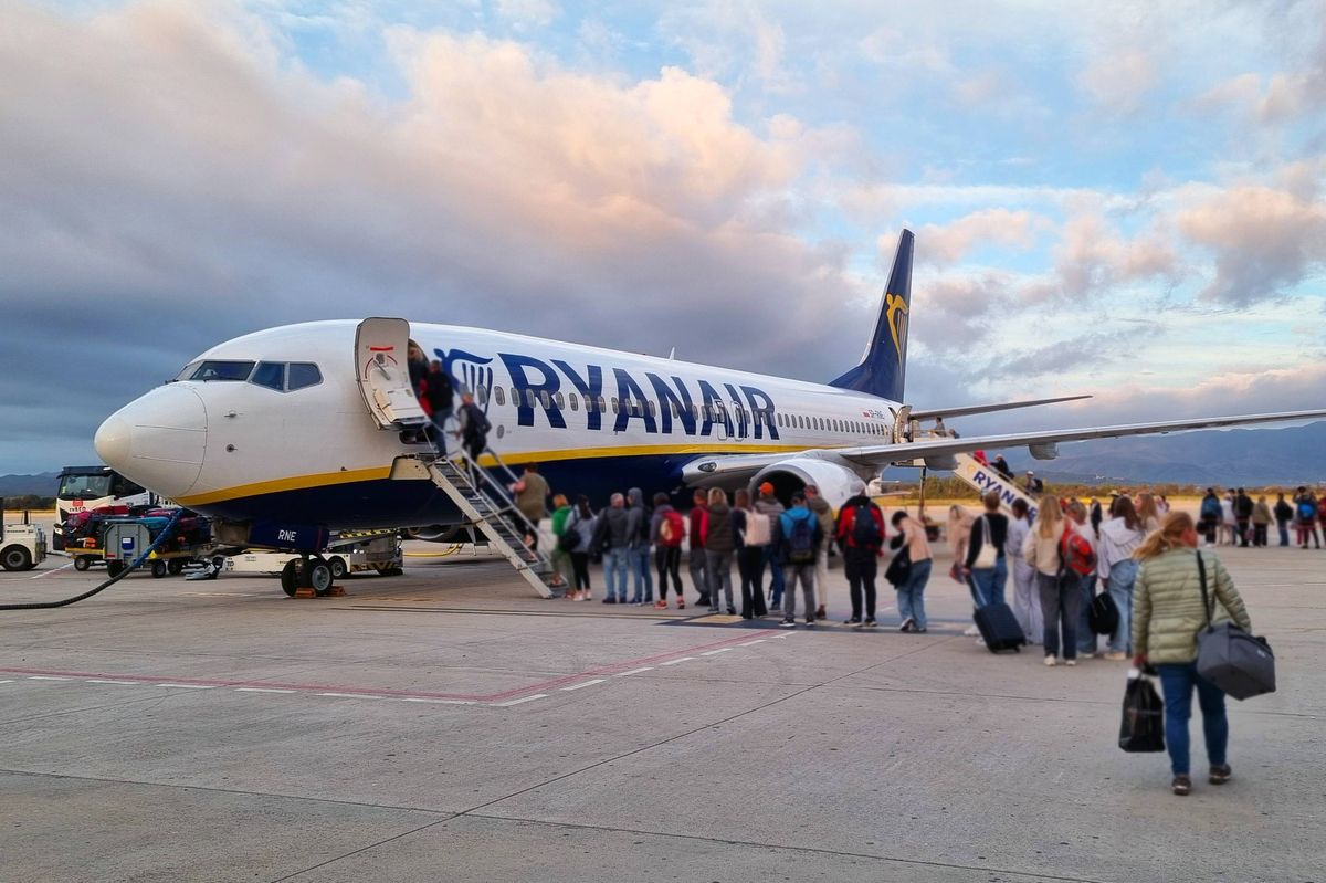 A bustling airport scene with passengers lined up to board a ryanair aircraft