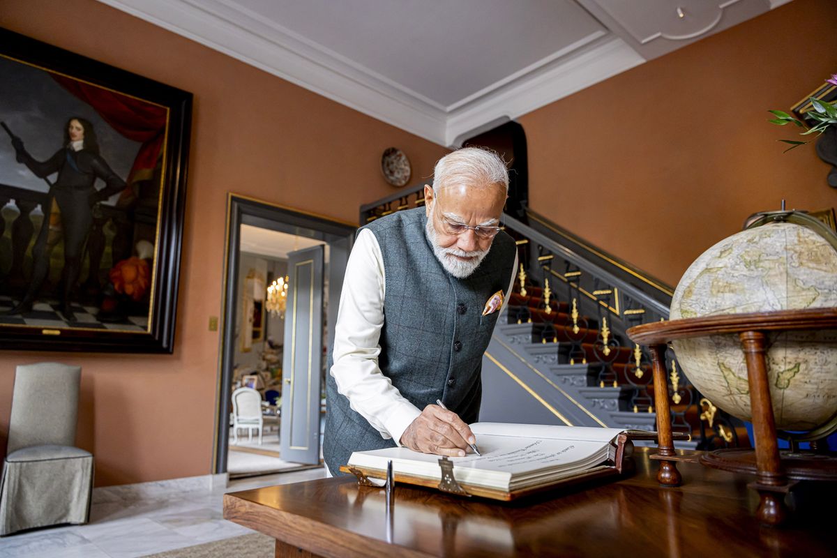 India's Prime Minister Narendra Modi signs the visitors book upon arriving to meet with Netherlands' King Willem-Alexander and Netherlands' Queen Maxima, at Huis ten Bosch Palace in The Hague.
