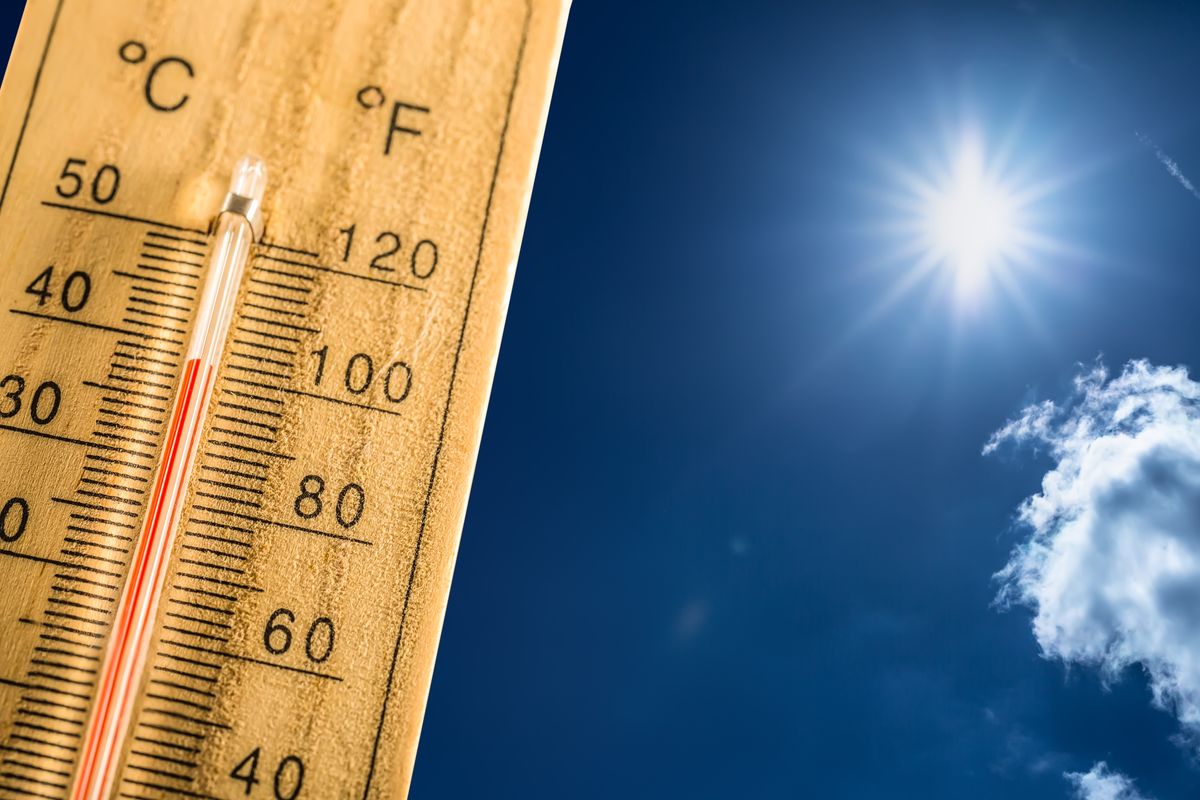 Hot summer day and forty degrees Celsius on a thermometer. Thermometer in summer day shows high temperature degree with sun in background.