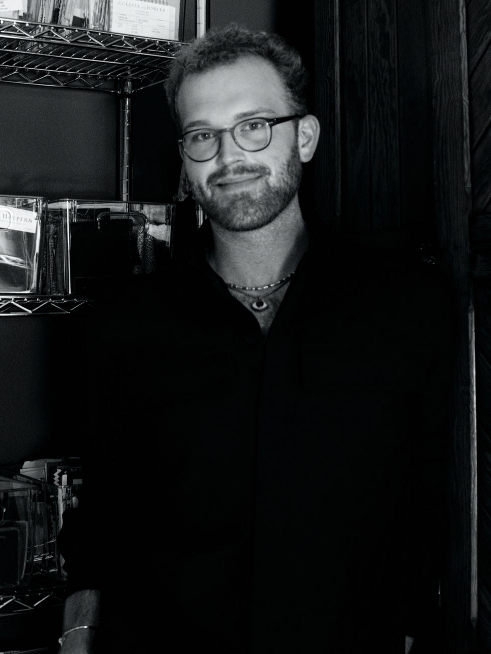 A person standing next to a shelf filled with items.