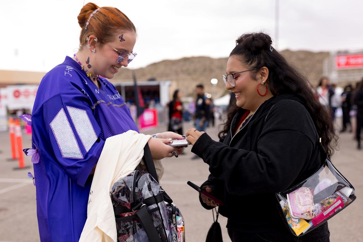 Morgan Belding, of Killeen, Texas, who has been a BTS fan since 2013, trades freebies with another fan outside the Sun Bowl in El Paso, Texas, on Saturday, May 2, 2026, before the first concert.