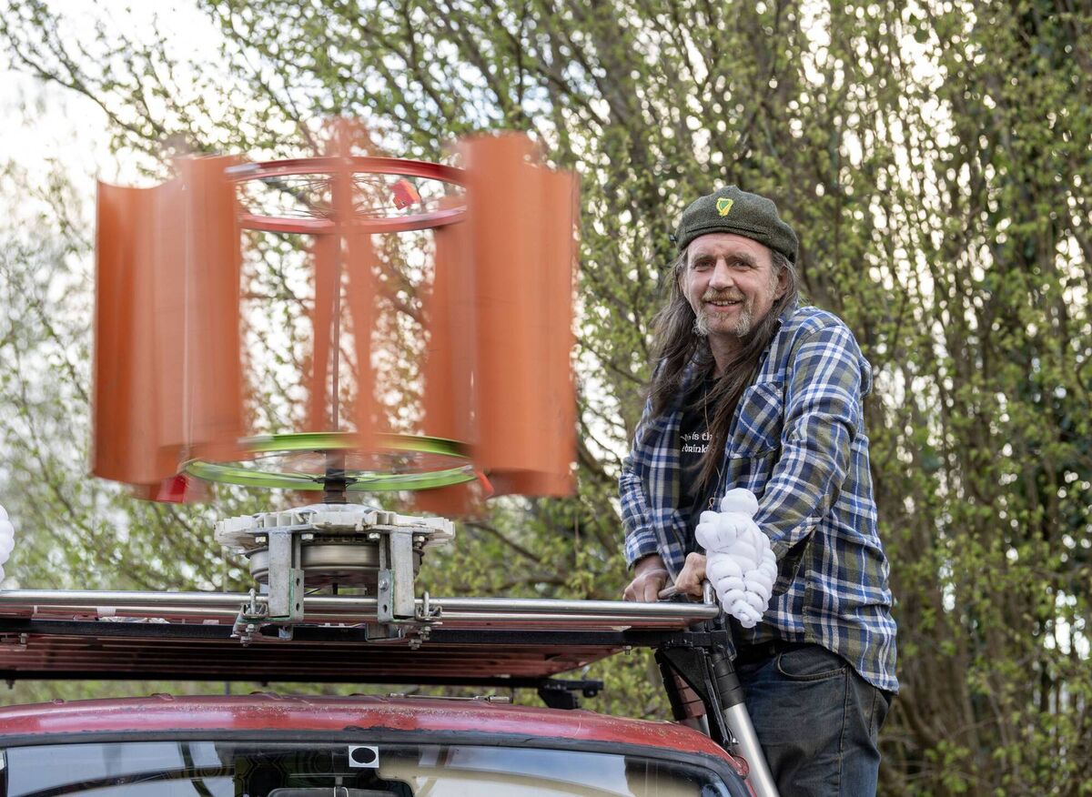 Barra with his wind turbine made from a sewer pipe, a bicycle wheel, and a washing machine motor. 