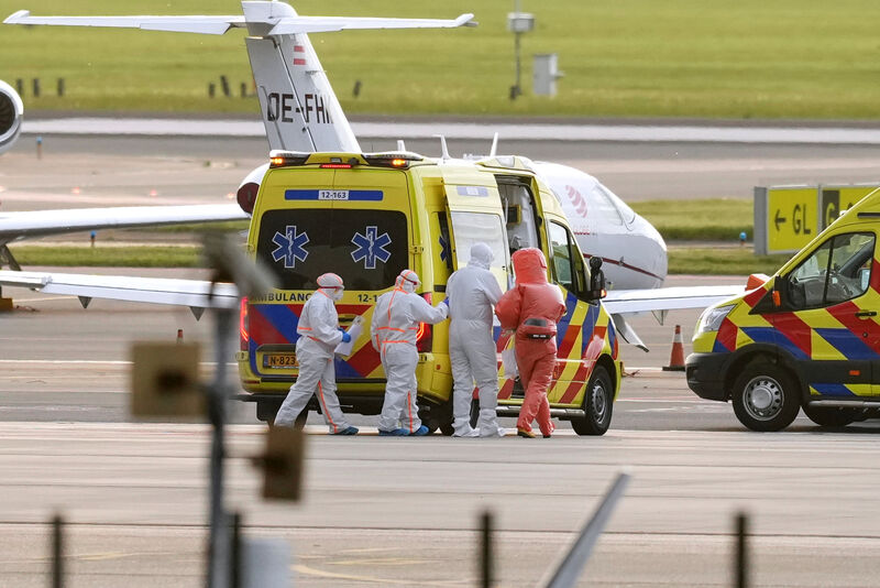 Medics escort a patients, evacuated from the MV Hondius cruise ship with suspected hantavirus infection, to an ambulance after being flown to Schiphol airport, Amsterdam, Netherlands, Wednesday, May 6, 2026. (AP Photo/Peter Dejong)