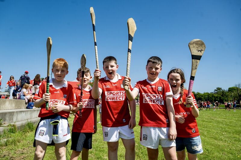Cork fans Cian O’Connor, Levi Gore, Kyle Mulcahy, Oisín O’Sullivan and Fiadh O’Sullivan raise their hurleys before the game on Sunday. Picture: Chani Anderson