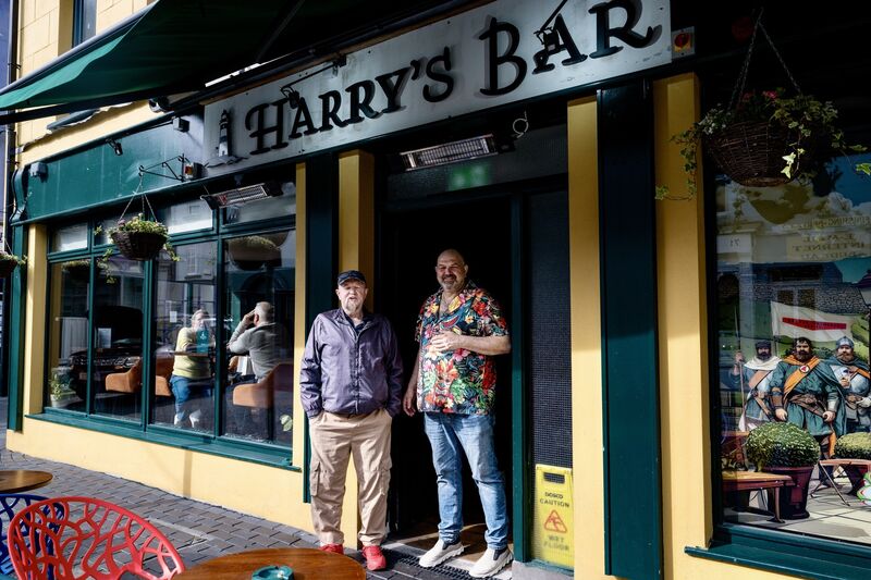 Graham D’Alton, owner of Harry’s Bar, pictured outside the pub in Kinsale with a regular customer. Picture Chani Anderson