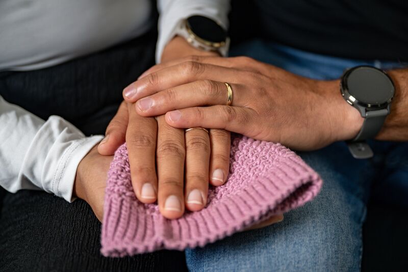 Daniela Gomez and Daniel Brenes hold a tiny hand-knitted hat made by Daniela’s mother for Alma, now kept as treasured reminders of their daughter who passed way moments after she was born. Picture: Chani Anderson