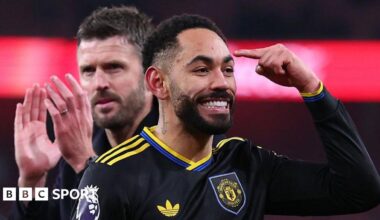 Matheus Cunha points to his head with Michael Carrick applauding behind him