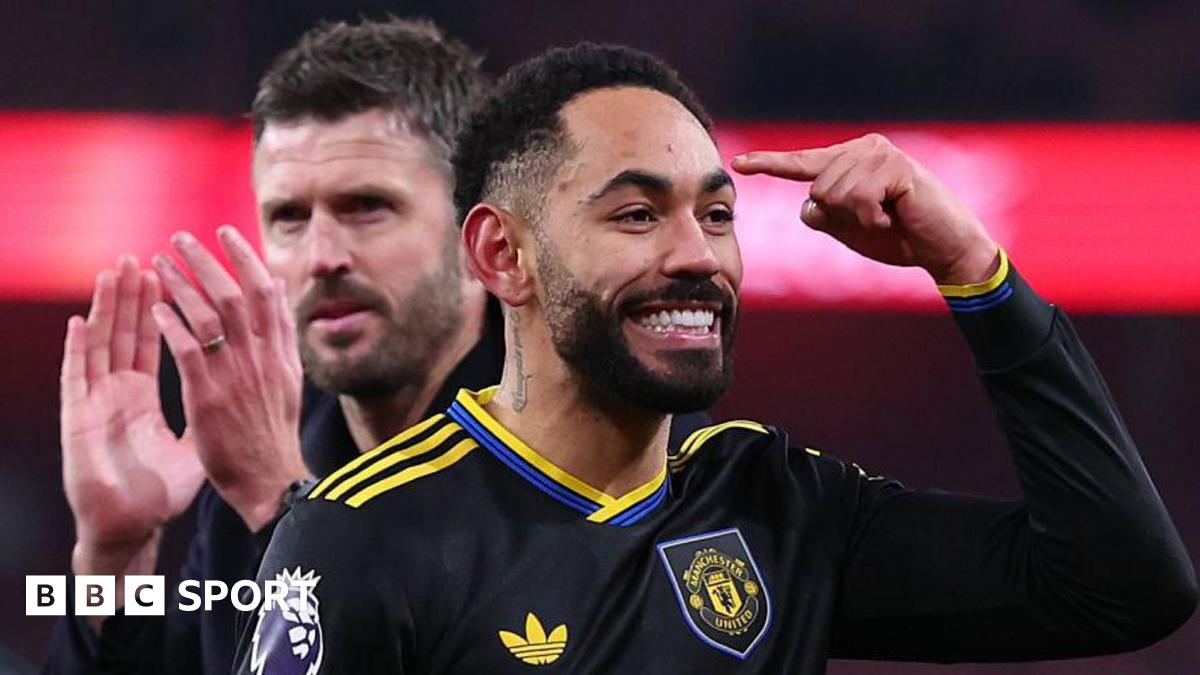 Matheus Cunha points to his head with Michael Carrick applauding behind him