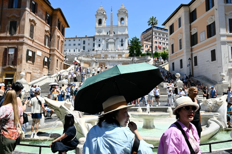 Tourists shield themselves from the sun with hats and umbrellas at the Spanish steps in Rome, during an early-season heatwave in Europe, on May 26, 2026.  Photograph: Alberto Pizzoli/AFP via Getty Images