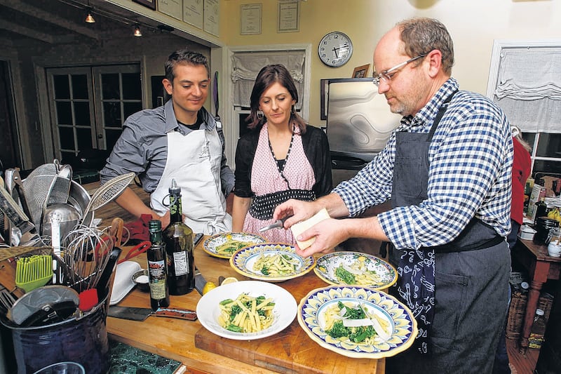 Los Angeles Times via Getty Images Food Editor Russ Parsons (right) teachs Carter Calhoun (left) and his fiancee Meghan Garvey (middle) put the final touches on cooked pasta prepared at Parson's Long Beach home on January 6, 2013