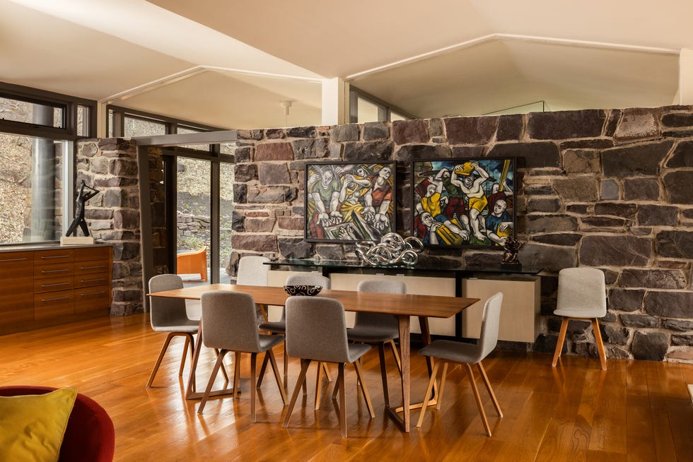 Modern dining area with stone wall and artwork