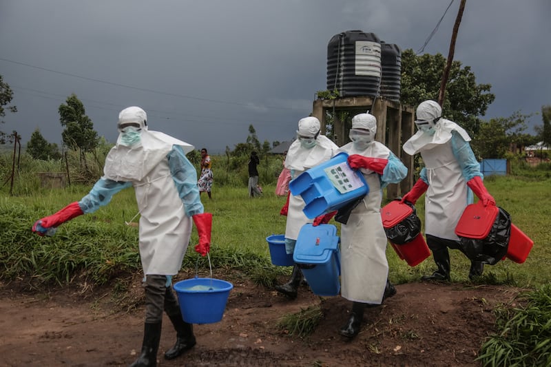 Medical staff wearing personal protective equipment (PPE) carry disinfectant at the hospital in Rwampara in DRC. Photograph: Seros Muyisa/AFP via Getty Images