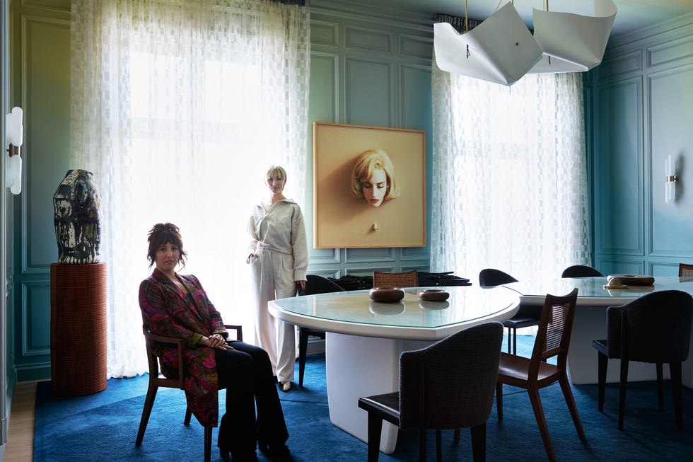 Modern dining space featuring two figures and artistic decor.