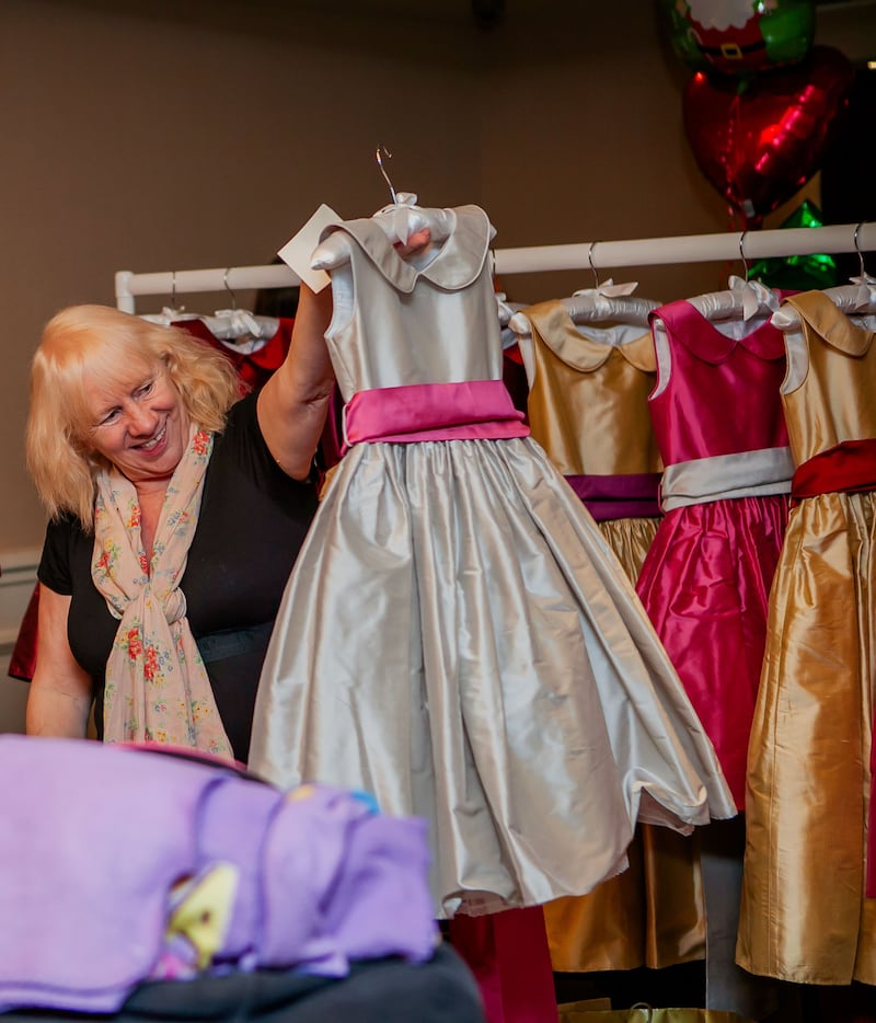 Jean O'Brien Jean holding up a dress in The Mother of All Cons.